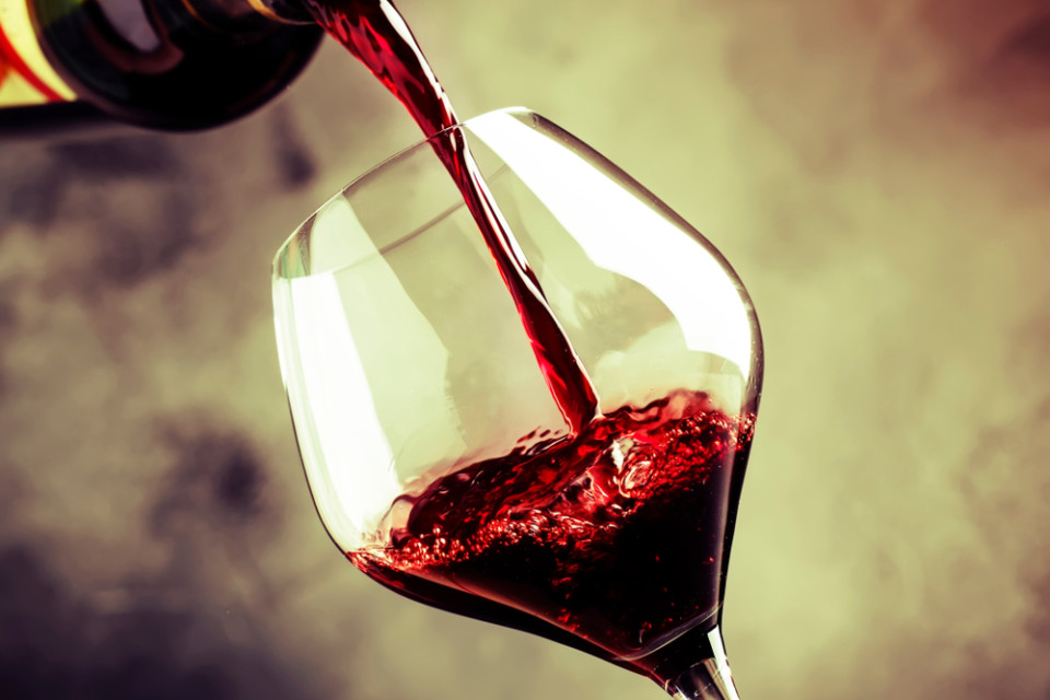 French,Dry,Red,Wine,,Pours,Into,Glass,,Gray,Background,,Selective